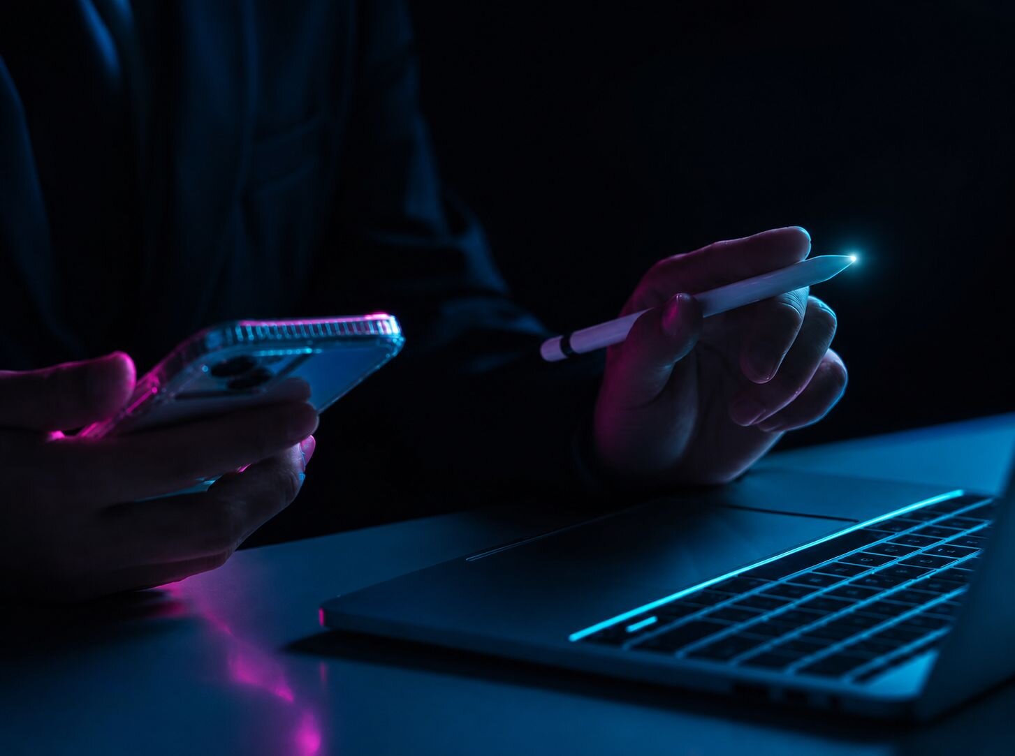 Hand holding phone at keyboard