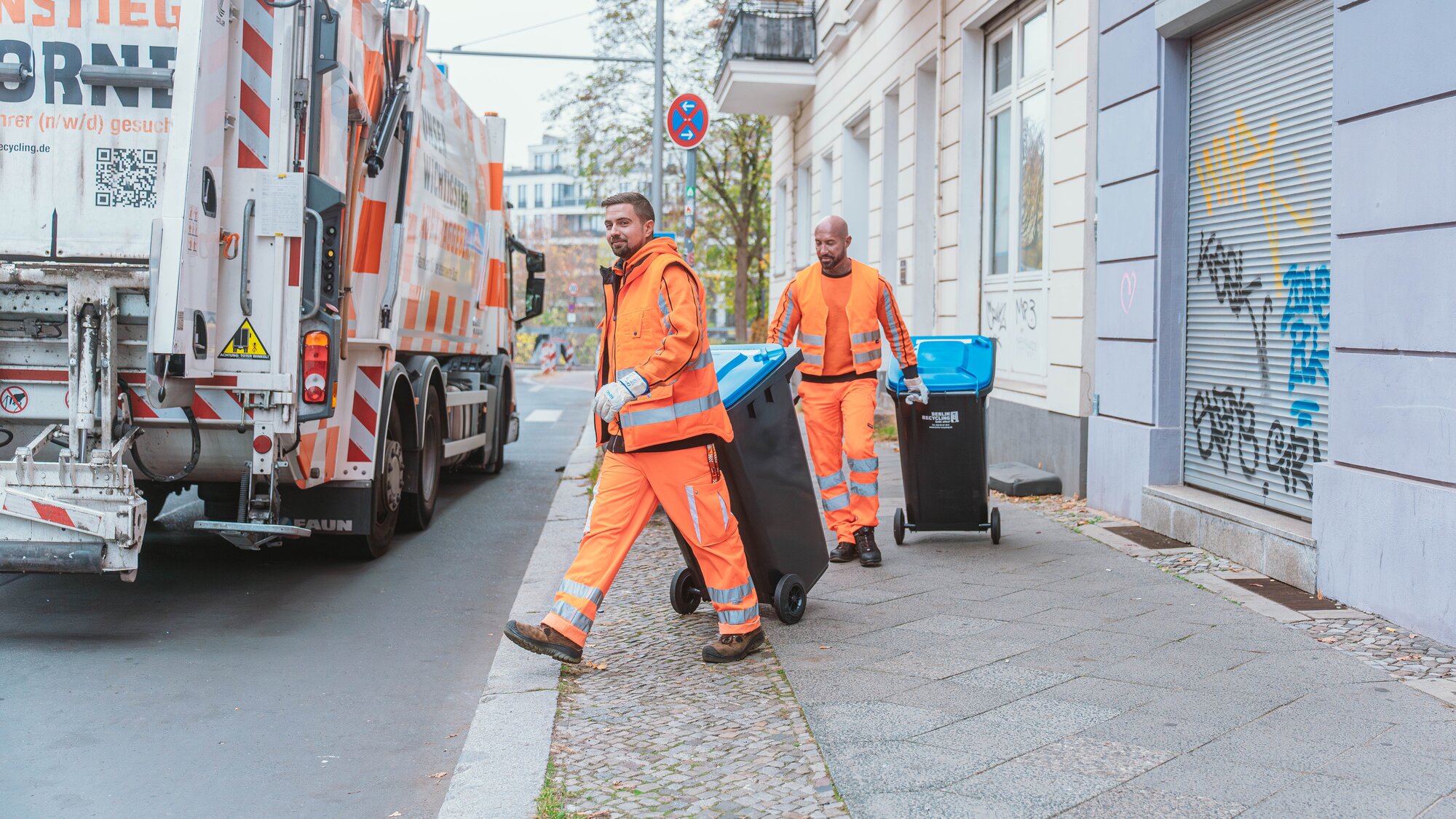 Berlin Recycling Mitarbeiter schieben Behälter