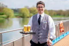 A server on the AmaCello sun deck serving beer