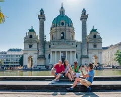 People sitting in front of a building in Vienna, Austria