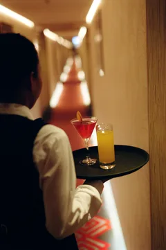 Crewmember brining drinks down hallway