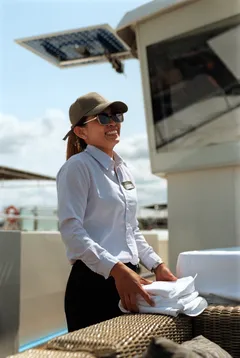 Crewmember with folded towels on ship deck