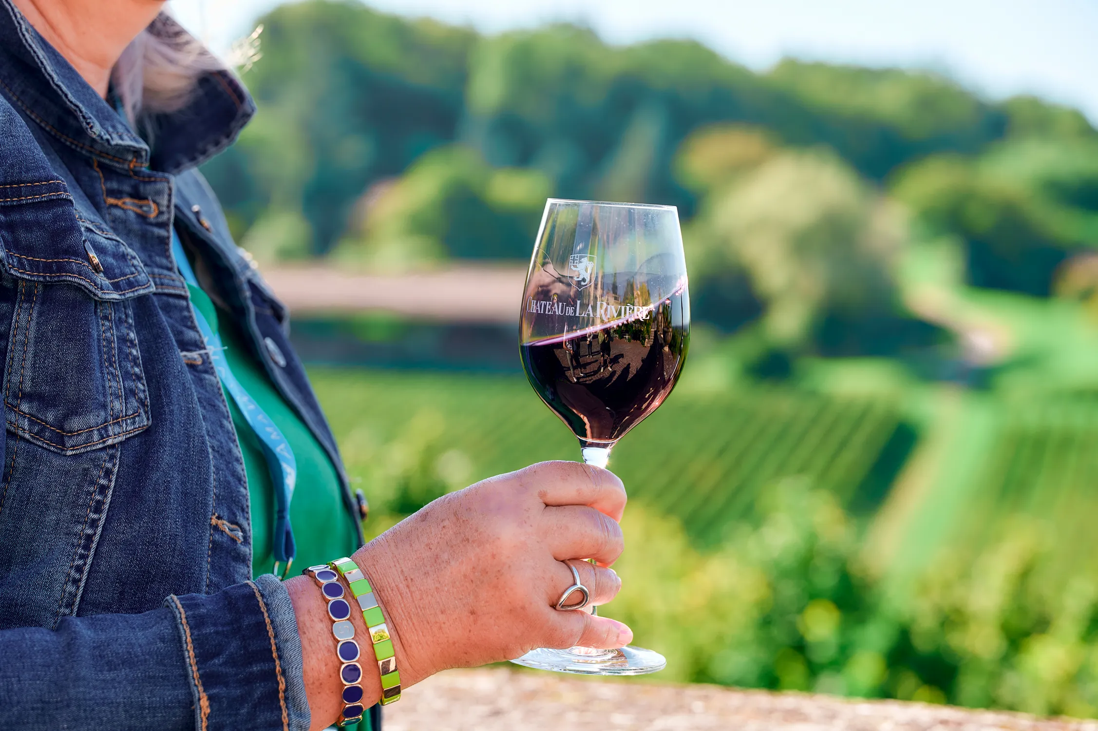 Person holding wine glass at a French vineyard