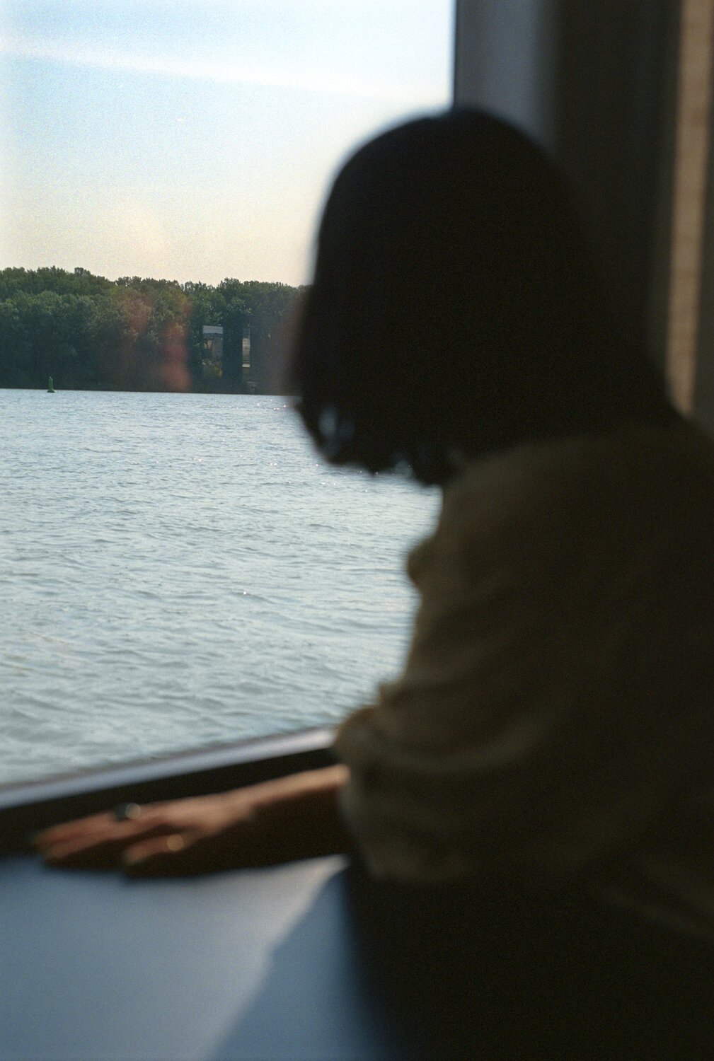 Woman looking out of ship window at river