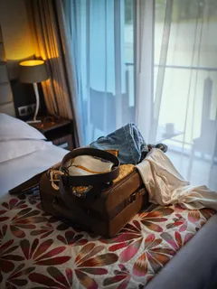 An opened luggage on top of a bed in a stateroom