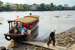 A group of people on a small boat docked on the shore in Vietnam