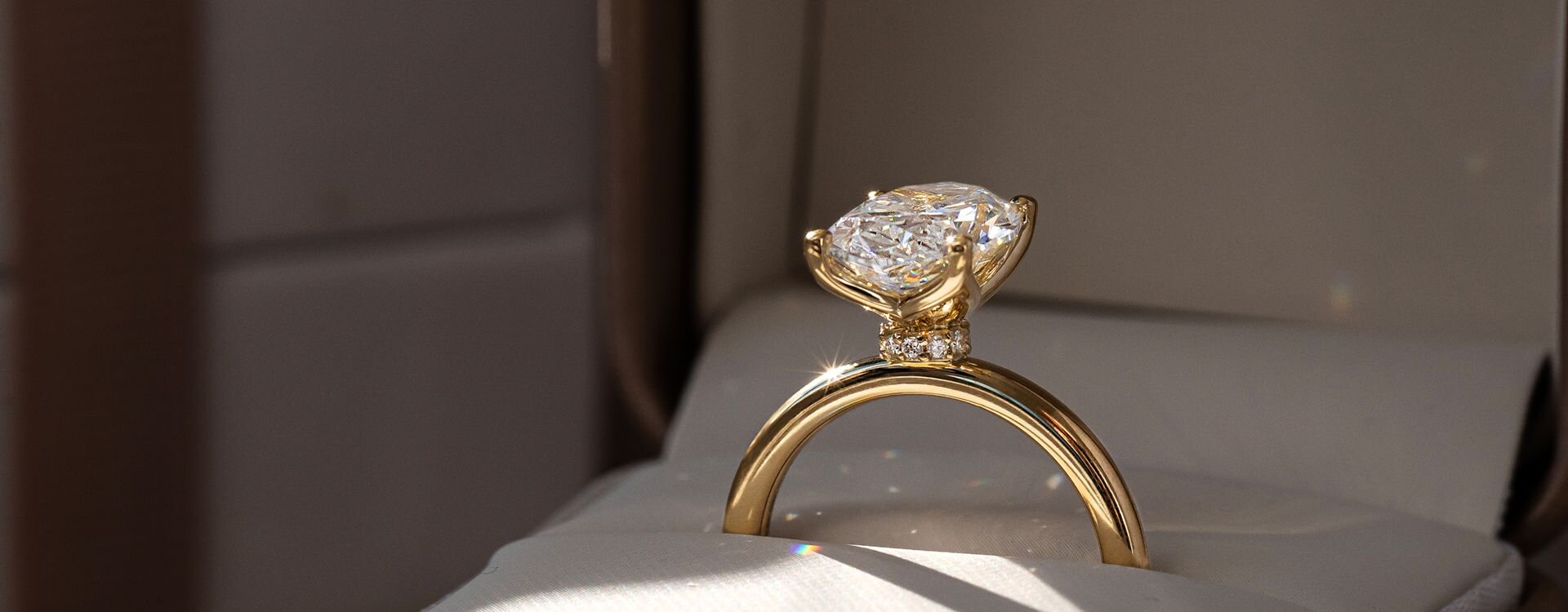Gold engagement ring with oval diamond in luxury jewelry box