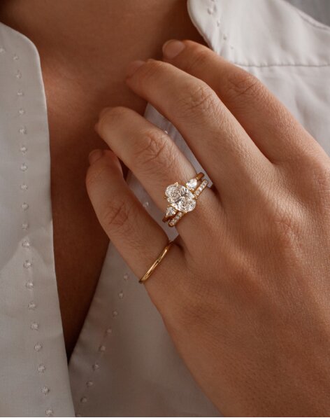 Oval diamond engagement ring and wedding band worn on hand