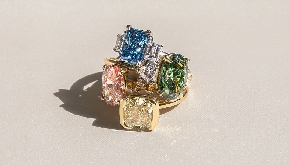 Stacked coloured gemstone rings with pink, blue, green and yellow stones