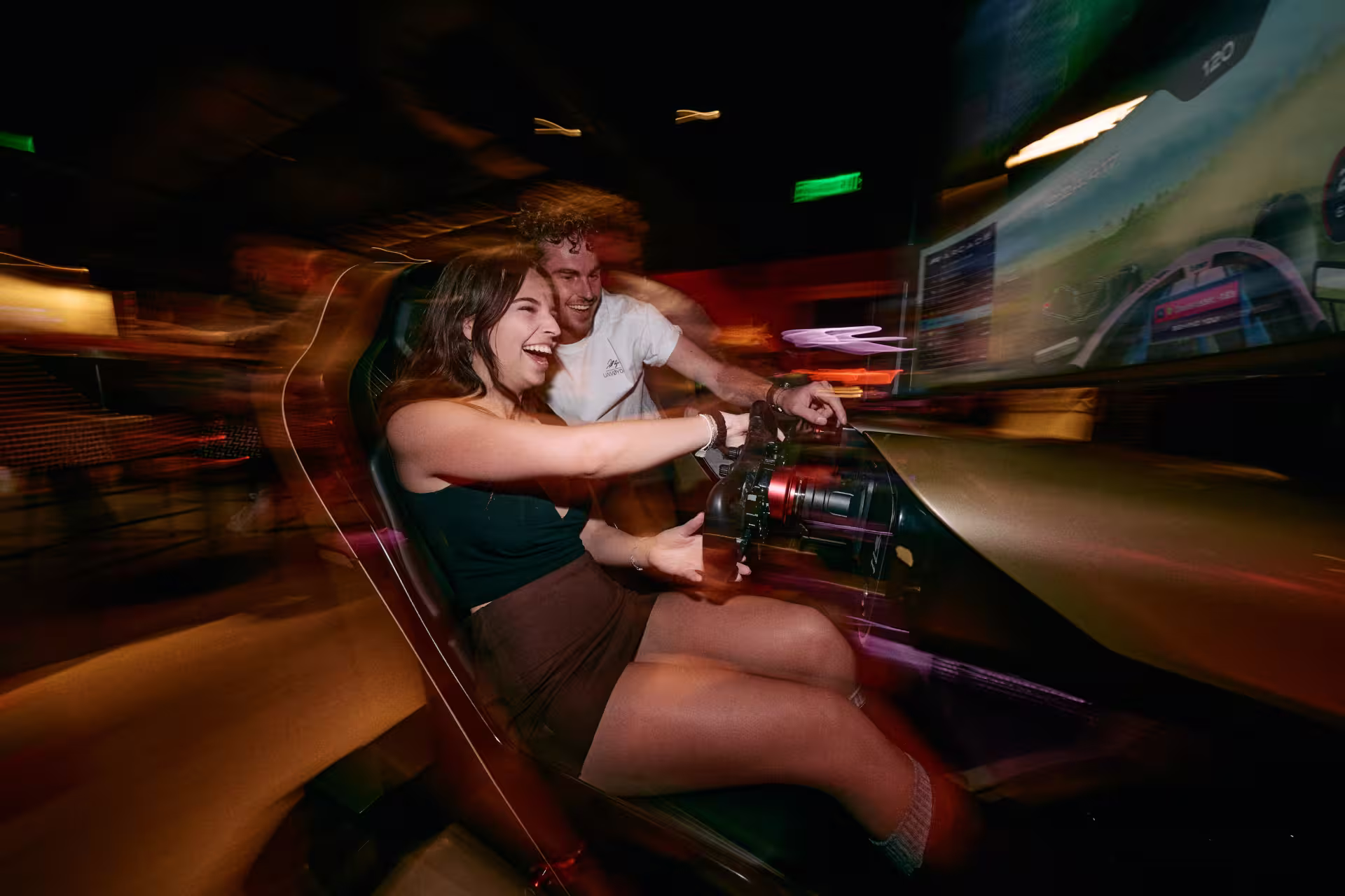 Guest enjoying Sim Racing at F1 Arcade while friend watches