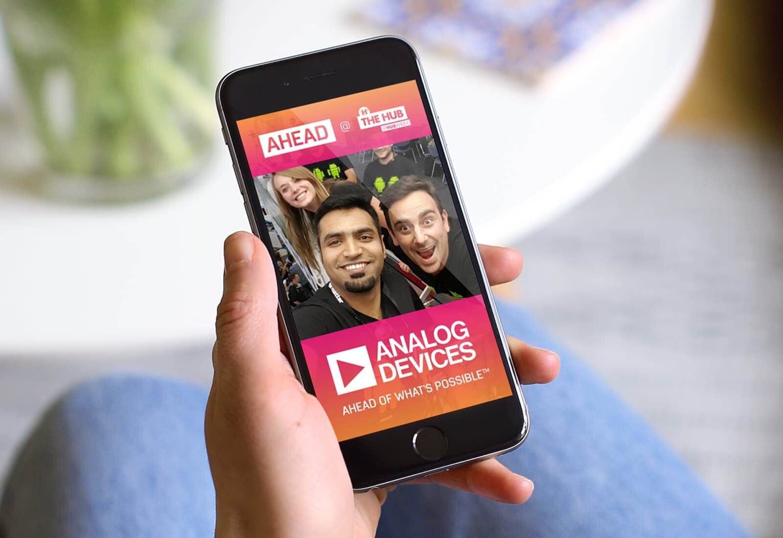 A hand holding a phone with an ADI social media post showing