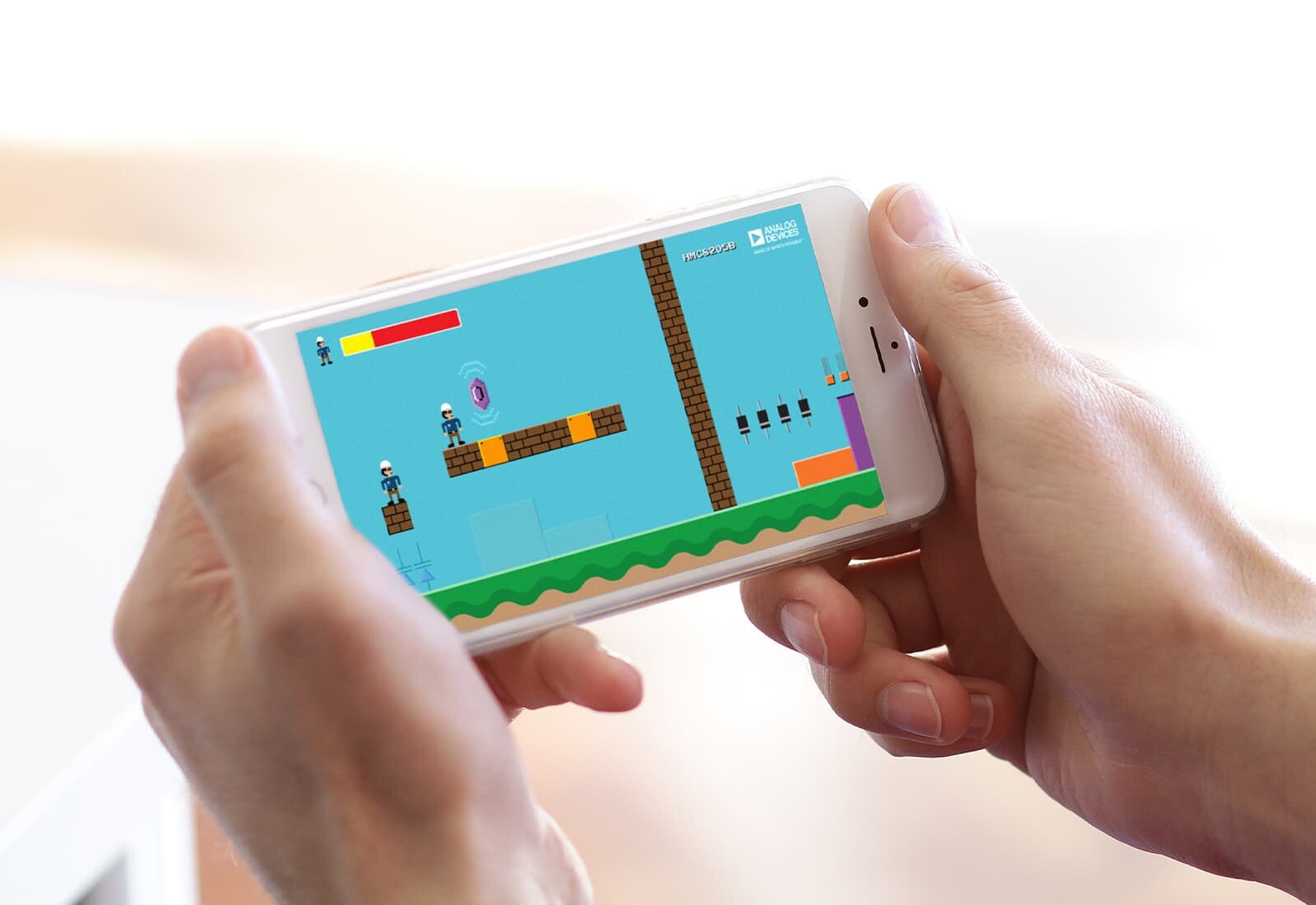 A pair of hands holding a phone with a platform game visible.