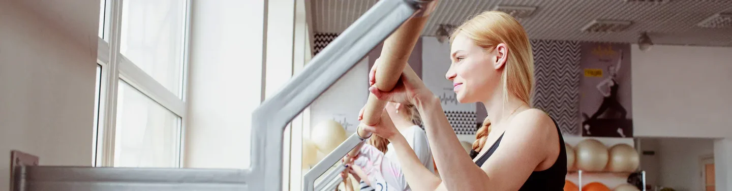 A group of women holding the barre during an exercise class