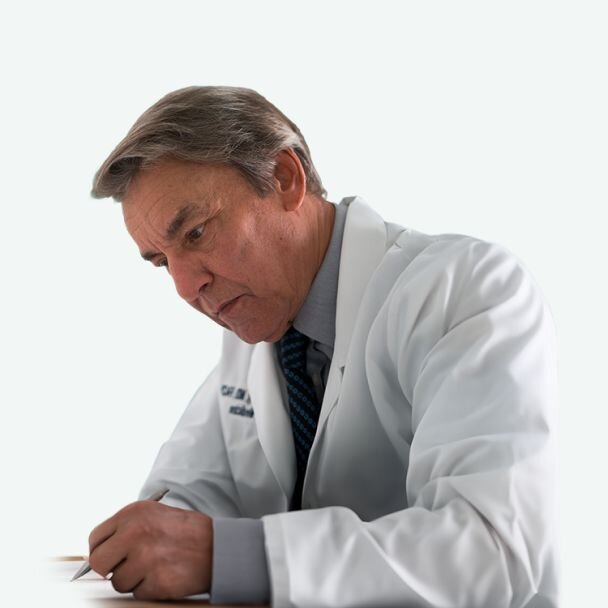 Dr. Larry May wearing a lab coat and writing