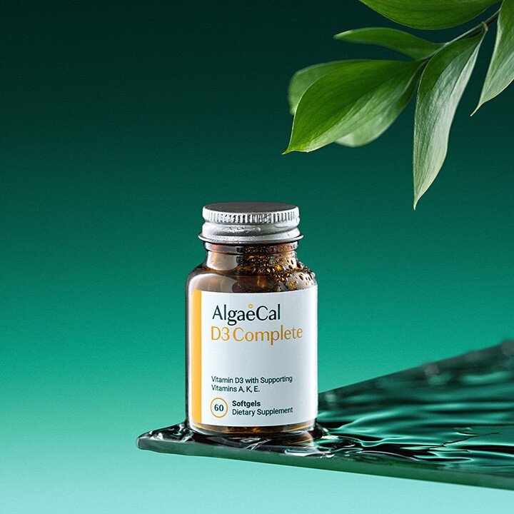 Bottle of AlgaeCal D3 Complete and a leaf in the foreground top right