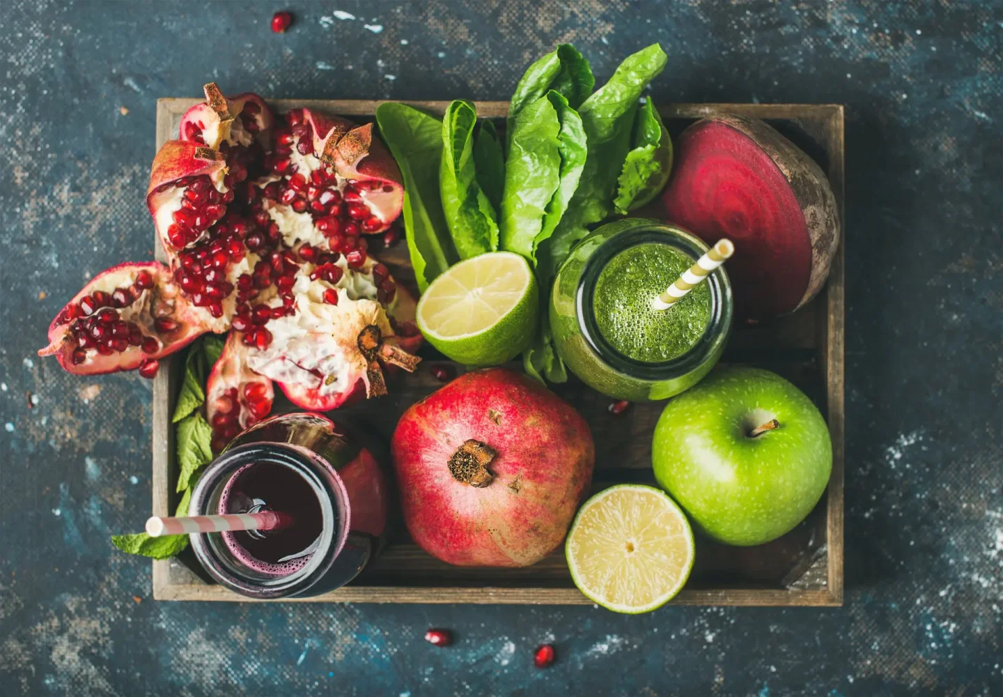tray of pomegranates, apple, lime and natural juices 