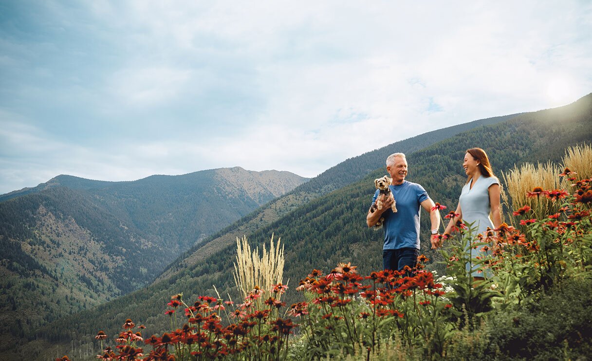 AlgaeCal founder, his wife and dog walking in a field of flowers