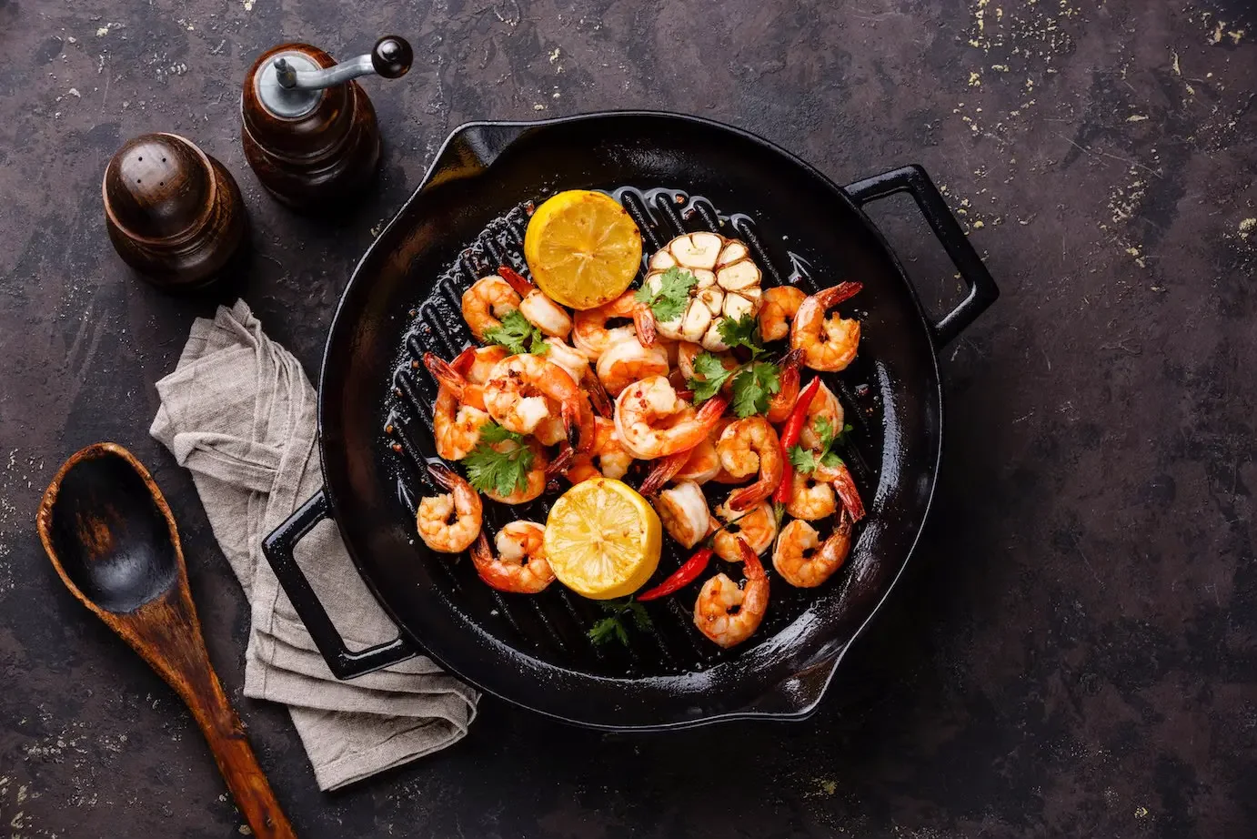overhead view of skillet of grilled shrimp with lemon and garlic 