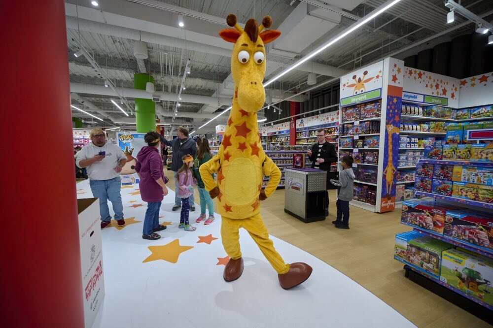 Geoffrey the Giraffe greeting families inside a Toys"R"Us store