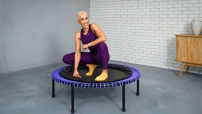 Une femme est assise sur un trampoline bellicon.