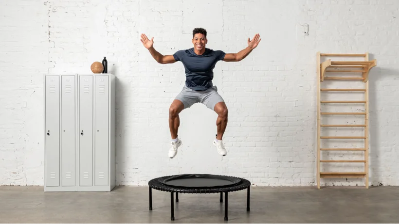 An happy man is doing a workout on the fitness rebounder from bellicon.