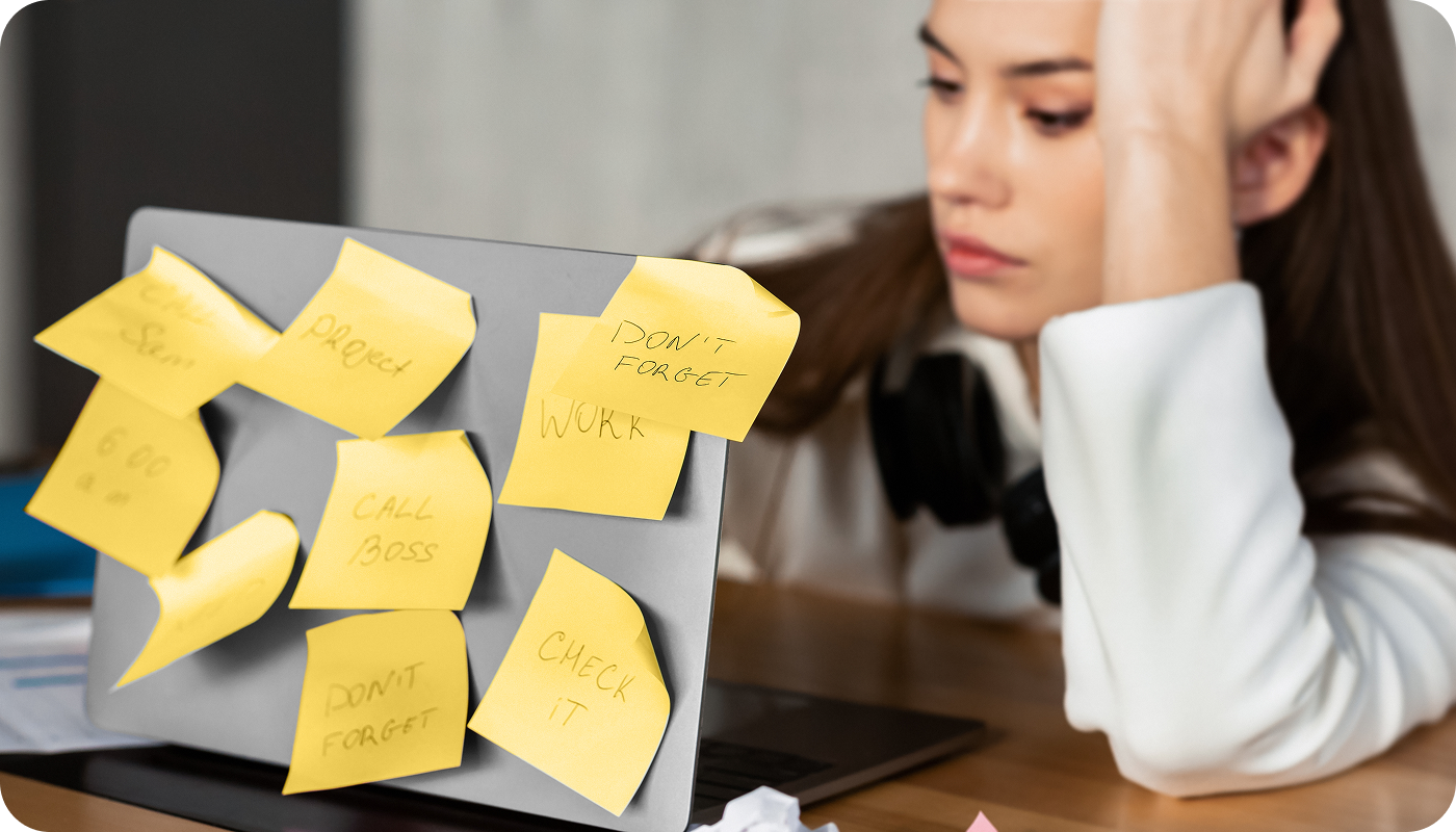 stressed woman at laptop with sticky notes