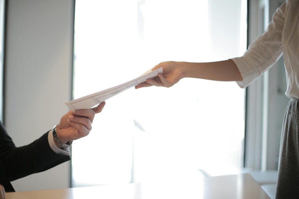 a person handing a document to another