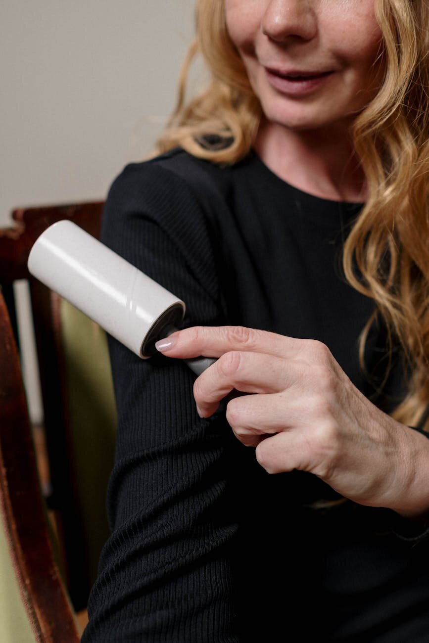 Lint roller being used to remove hair off a back shirt