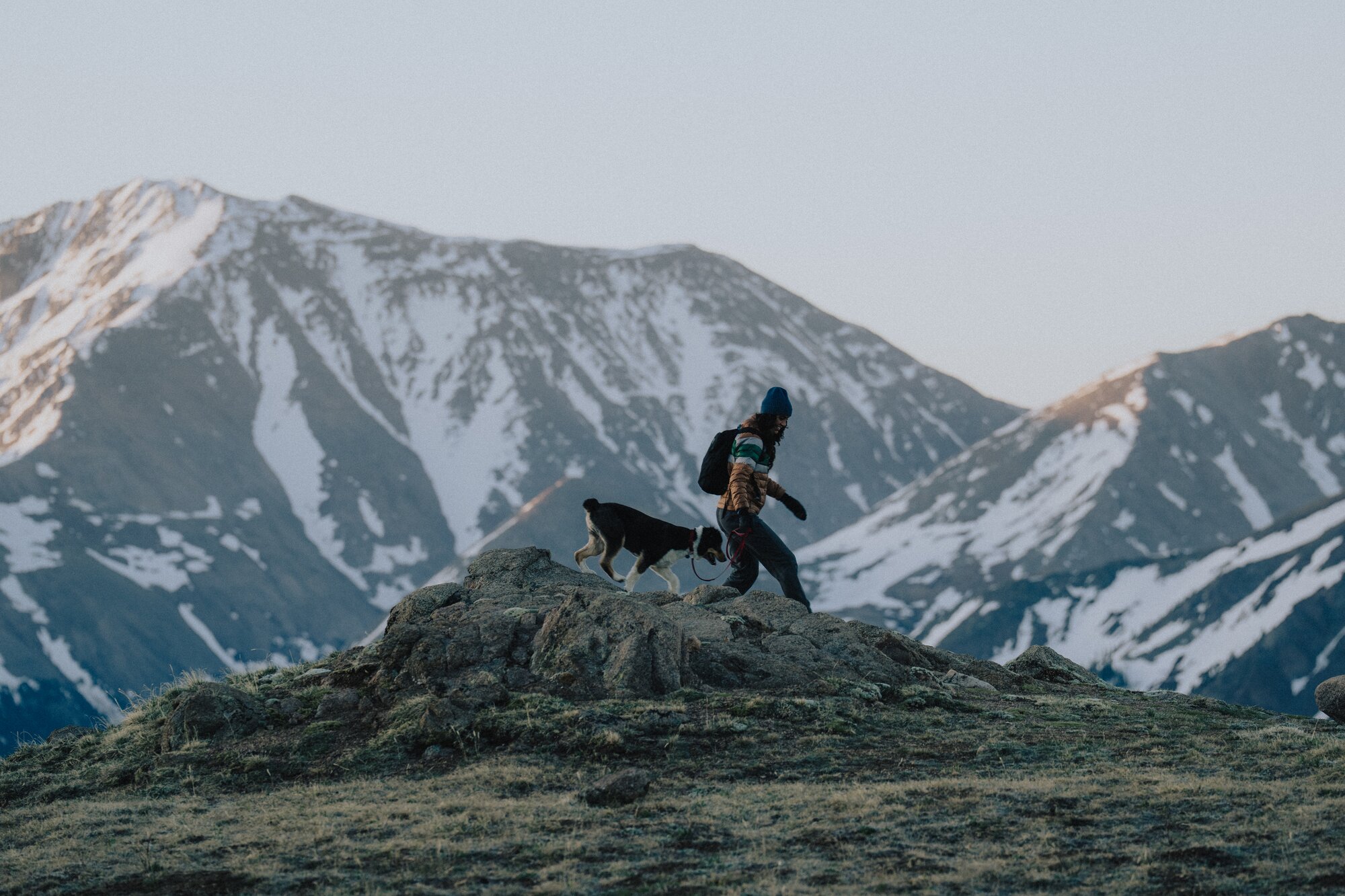 woman and dog hiking through mountains