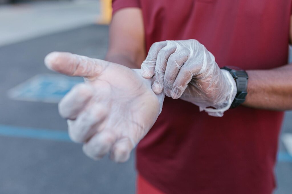 human putting on plastic gloves