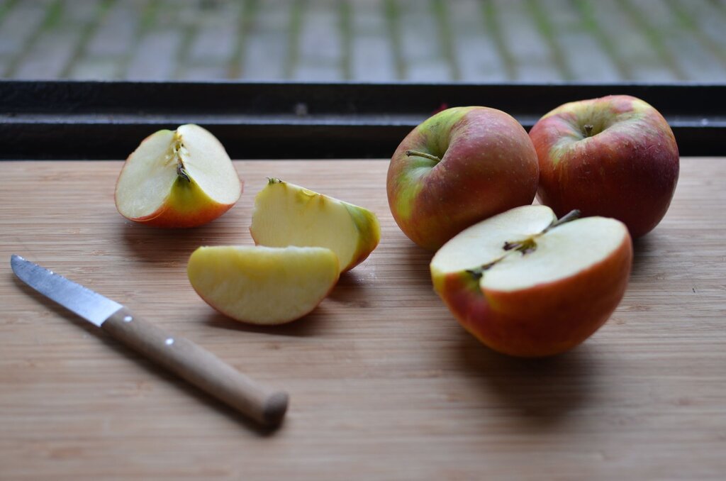 whole and cut apples on chopping board