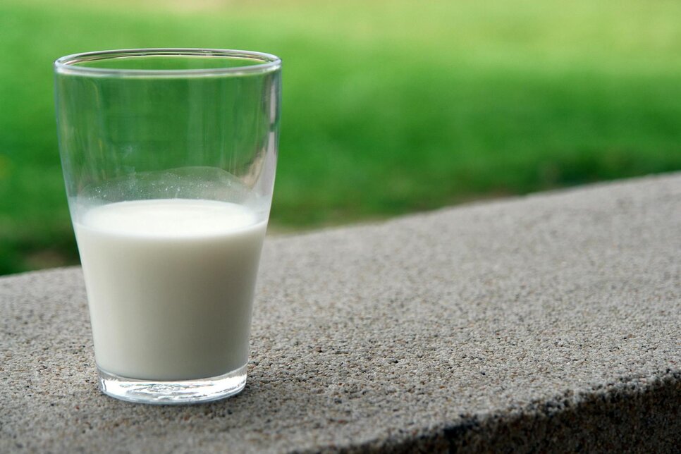 a glass of milk sitting on a wall