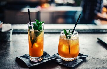 2 cocktails sitting on a counter top