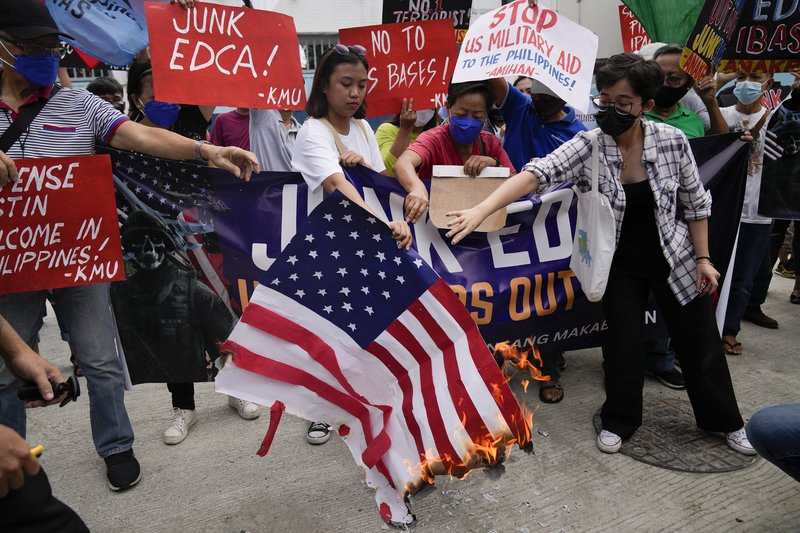 Demonstrators burn a mock U.S. flag as they protest against the visit of U.S. Defense Secretary Lloyd Austin outside Camp Aguinaldo military headquarters in metro Manila, Philippines on Thursday, Feb. 2, 2023. Austin is in the Philippines for talks about deploying U.S. forces and weapons in more Philippine military camps to ramp up deterrence against China's increasingly aggressive actions toward Taiwan and in the disputed South China Sea. (AP Photo/Aaron Favila)