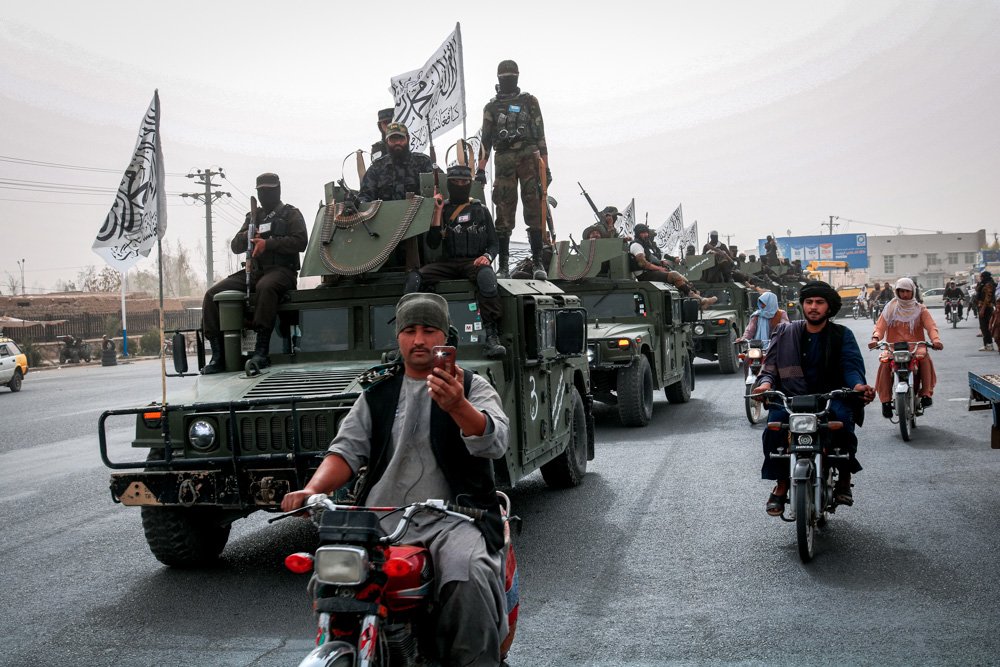 Taliban fighters patrol on the road.