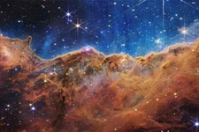 Captured by NASA's new James Webb Space Telescope, this image reveals previously invisible areas of star birth in the Carina Nebula. The tallest "peaks" in the image are 7 light-years high. NASA photo.