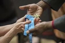 Army civilian employees pass around Retired Master Sgt. Leroy Petry’s Medal of Honor while attending a Mental Health Awareness Observance May 17, Heritage Hall, Rock Island Arsenal, Illinois. Petry asked the audience to pass around his medal while he served as one of the keynote speakers during the event. Photo courtesy of DVIDS.