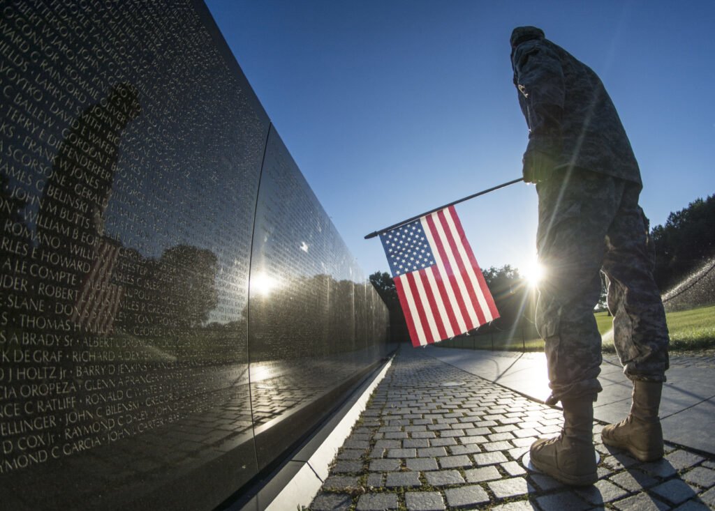 A U.S. Army Reserve soldier reads some of the 58,307 names etched into "The Wall" of the Vietnam Veterans Memorial in Washington, D.C. as the sun rises July 22, 2015. Photo by Sgt. Ken Scar/U.S. Army, courtesy of DVIDS.