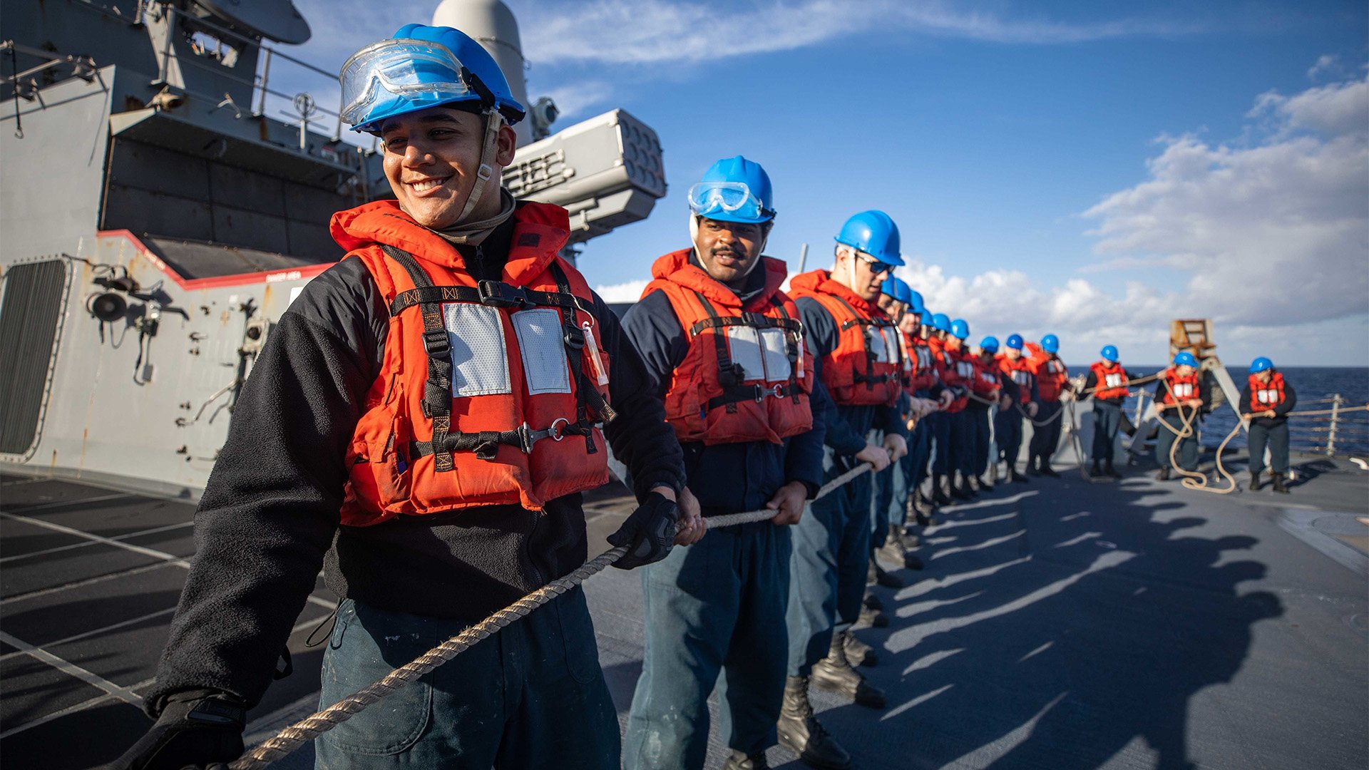 Sailors hold a line on board the Arleigh Burke-class guided-missile destroyer Rooseveltduring a replenishment-at-sea with the fast combat support ship Arctic on Nov. 22, 2022, in the Ionian Sea. More of them now get the chance to stay in the Navy and advance in rank, thanks to reforms to the high-year tenure program announced Dec. 22, 2022. US Navy photo by Mass Communication Specialist 2nd Class Danielle Baker.