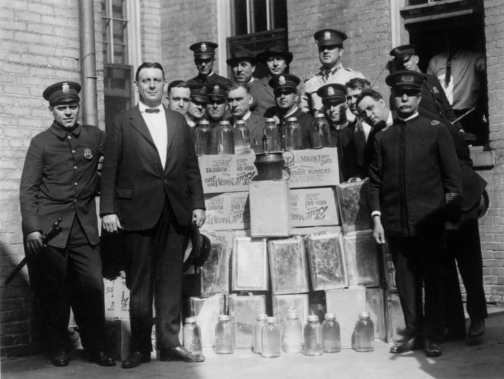 Group portrait of a police department liquor squad posing outdoors with cases of confiscated alcohol and distilling equipment during Prohibition.  (Photo by Archive Photos/Getty Images)