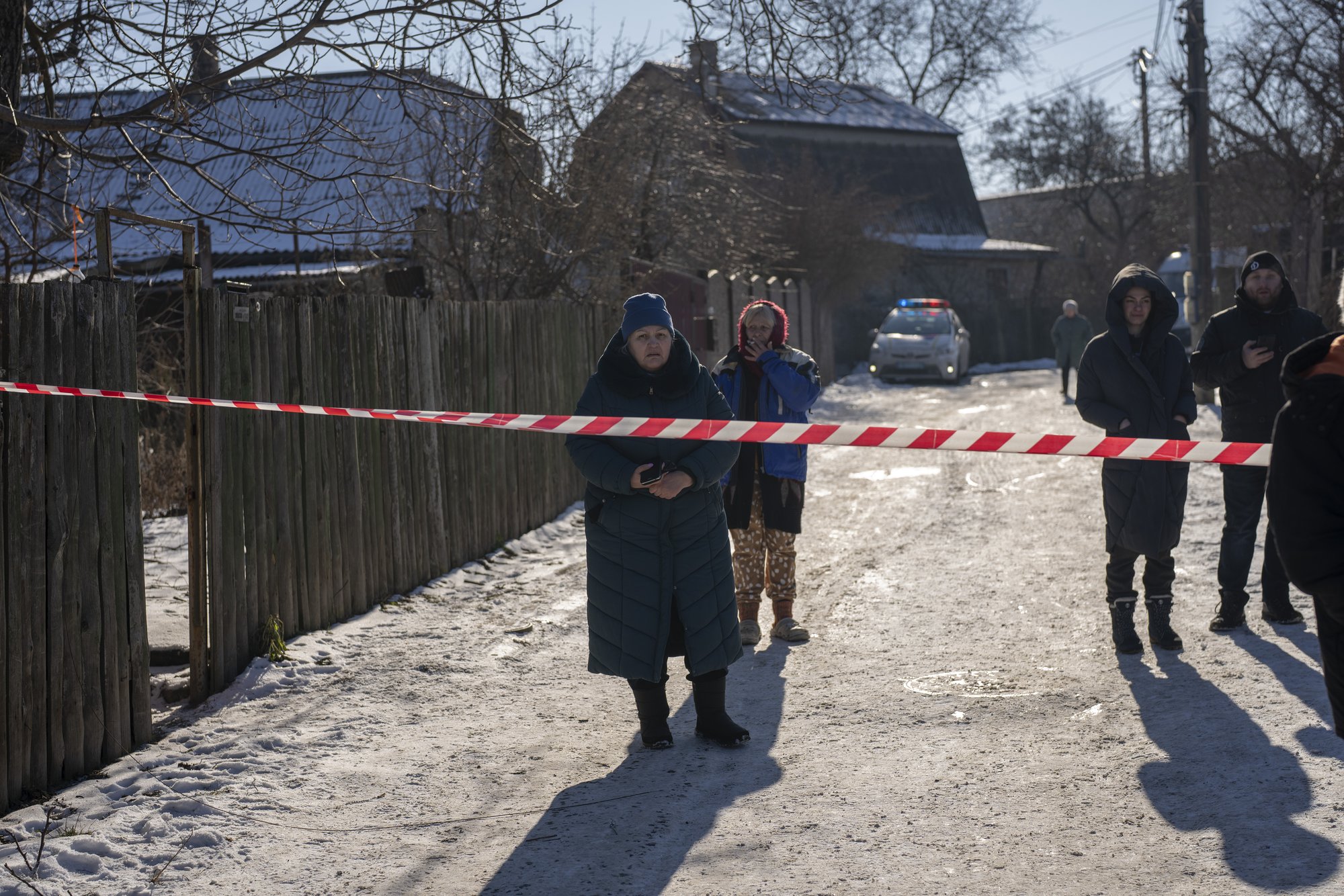 Residents wait behind police cordon to return to their homes after a rocket attack in Kyiv suburbs, Ukraine, Friday, Feb. 10, 2023. Russian forces have unleashed a barrage of missile and drone strikes against targets in eastern and southern Ukraine. The Ukrainian military said the Kremlin's forces focused their bombardments early Friday on Ukraine's industrial east, especially the Luhansk and Donetsk provinces. (AP Photo/Emilio Morenatti)