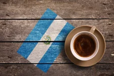 Salvador flag with coffee on table. top view. Adobe Stock photo.