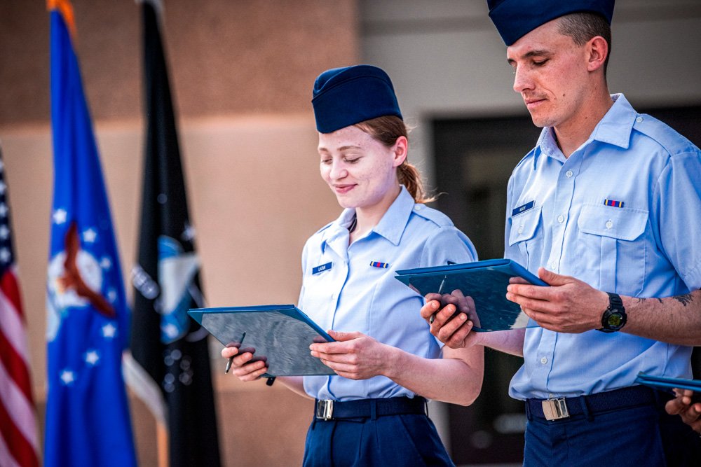 Airman 1st Class Natalia Laziuk, from Russia, left, and Airman 1st Class Ross Mudie, from South Africa, look at their U.S. Certificates of Citizenship