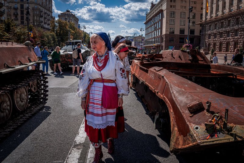 People look at a large number of burned out and captured Russian tanks and infantry carriers 