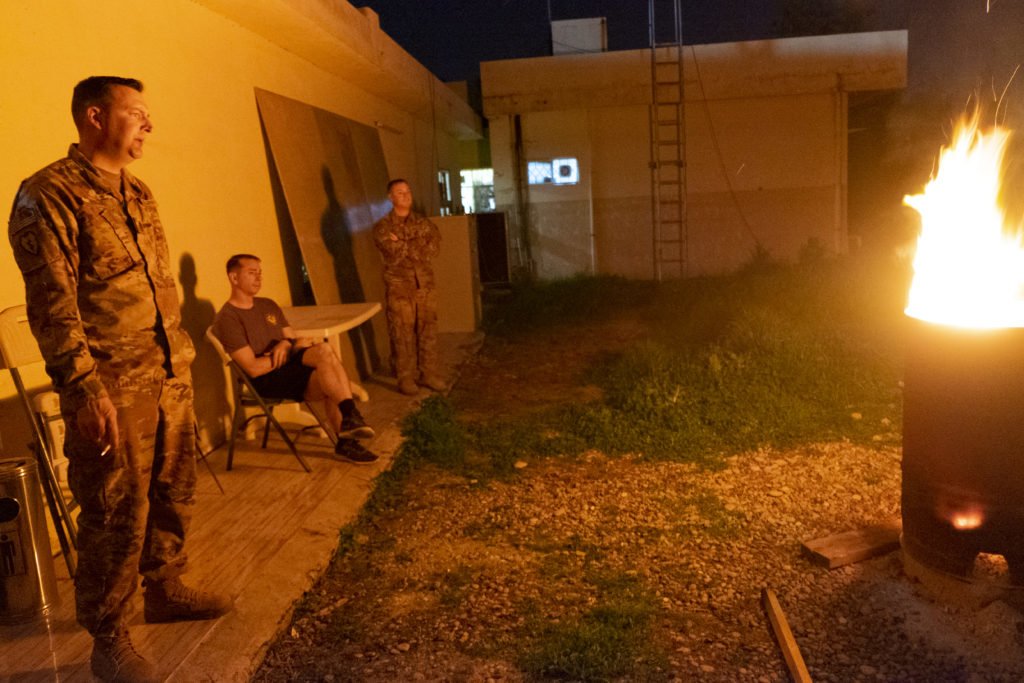 Soldiers have a fire outside the squadron headquarters. Photo by Kevin Knodell/Coffee or Die.