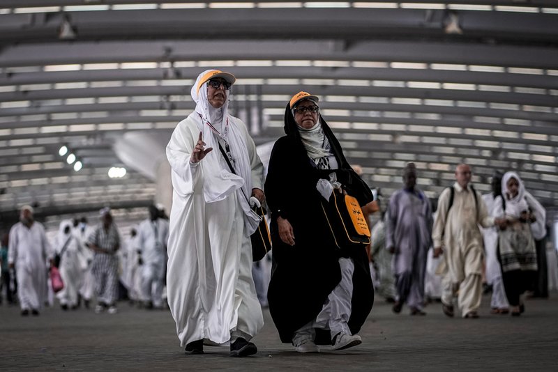 Iranian pilgrims walk to cast stones at a pillar in the symbolic stoning of the devil.
