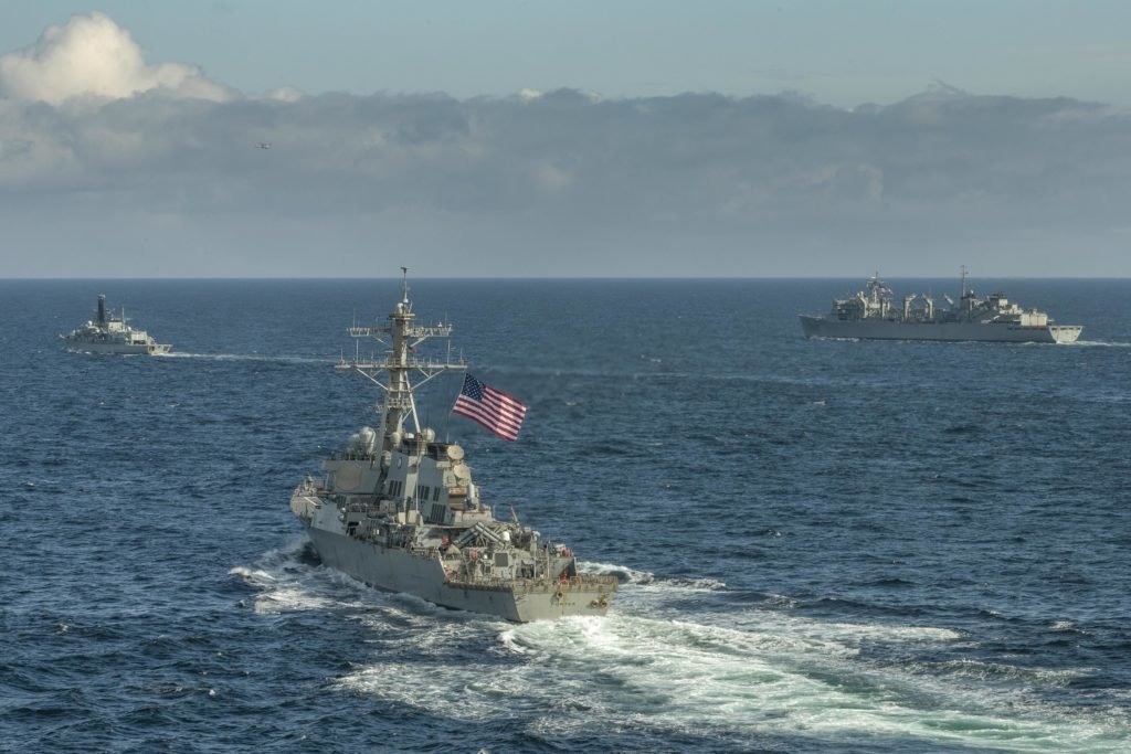 The Arleigh Burke-class guided-missile destroyer USS Porter (DDG 78), front, and the fast combat support ship USNS Supply (T-AOE 6), right, transit the Arctic Ocean with the Royal Navy Type-23 Duke-class frigate HMS Kent (F78) while conducting joint operations to ensure maritime security, May 5, 2020. U.S. Navy photo courtesy of the Royal Navy by Royal Navy Photographer Dan Rosenbaum/Released.