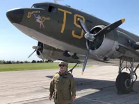 The author in front of the “Southern Cross,” a C-47 troop transport like one of the 2,000 planes that dropped thousands of American paratroopers over Normandy on D-Day. Photo by Julia Akoury.