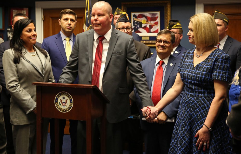 Major Richard Star holds his wife, Tonya's, hand as he speaks at a press conference in Washington, D.C., in support of H.R. 5995, the Major Richard Star Act, on March 3, 2020. Photo courtesy of Jen Milbrett/Military Officers Association of America.