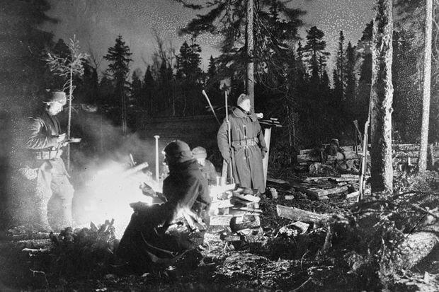 US soldiers warm themselves by a campfire on the front lines in northern Russia in January 1919, two months after armistice. Photo courtesy of the Library of Congress.